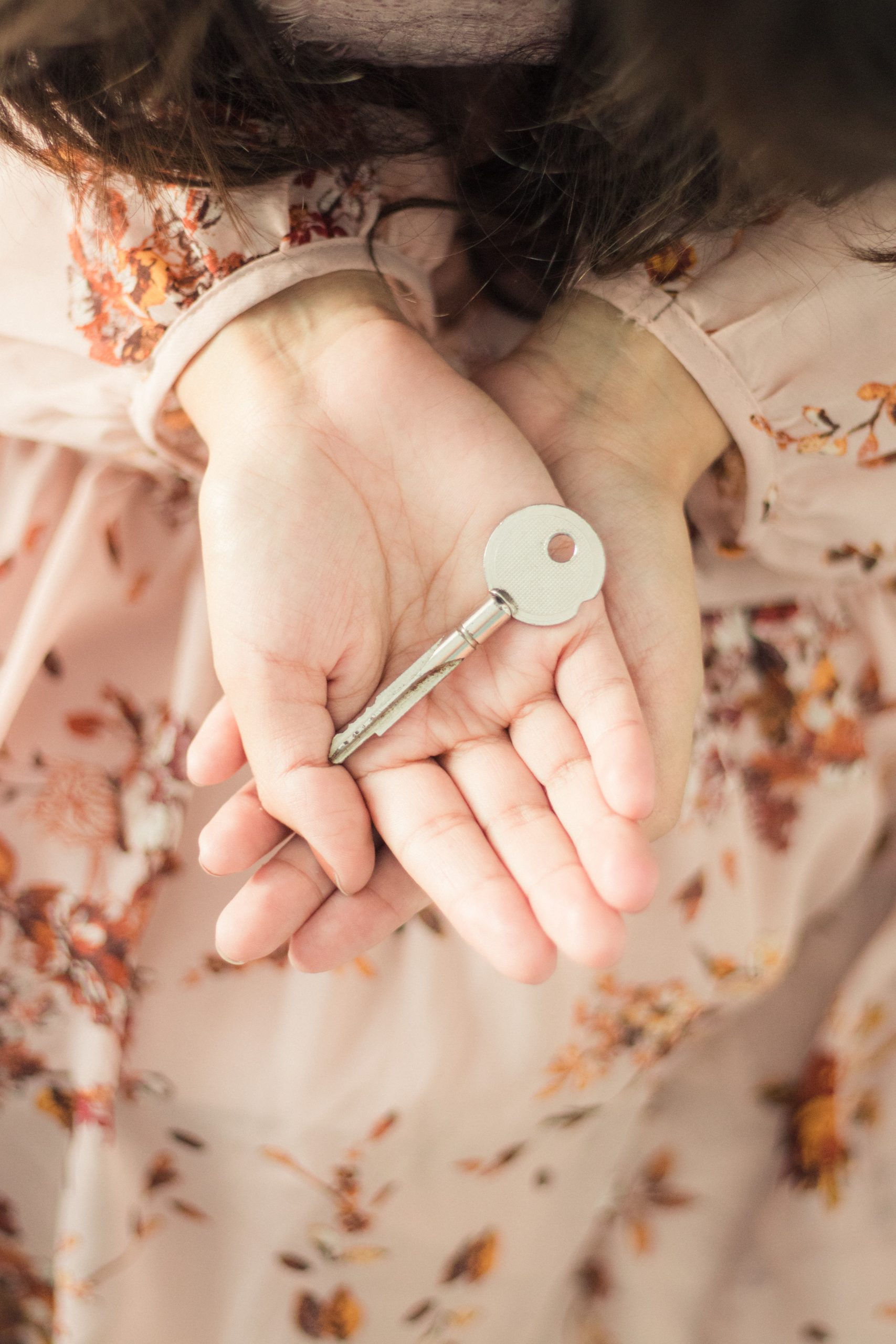 Close-up of hands holding a key symbolizing unlocking financial wisdom for midlife women with Sarah McGirr Coaching